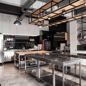 an industrial kitchen with stainless steel tables and wooden top island
